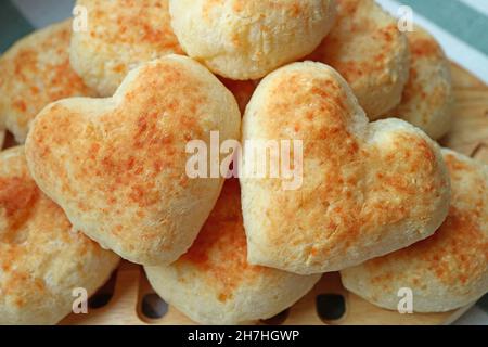 Gros plan paire de délicieux pains de Pao de Queijo ou de fromage brésilien frais en forme de cœur sur la pile Banque D'Images