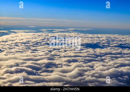 ciel bleu et nuages vus à travers la fenêtre de l'avion Banque D'Images