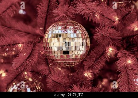 Sapin de Noël avec décorations, boule dorée brillante. Vacances d'hiver. Couleur bordeaux tendance. Mise au point sélective. Banque D'Images