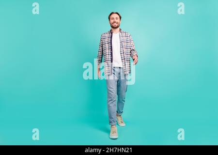 Pleine longueur corps photo homme souriant marche avant isolé pastel turquoise couleur fond Banque D'Images