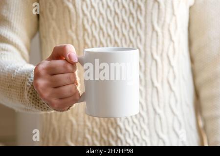 femme main tenant une tasse blanche avec espace de copie vierge scree pour votre message texte publicitaire ou contenu promotionnel, café sucré ou thé.Fille beige Banque D'Images