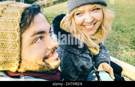 Couple heureux dans l'amour appréciant le temps à l'extérieur sur le tissu d'hiver - beau homme et jeune femme parlant et s'amusant ensemble - concept de relation Banque D'Images