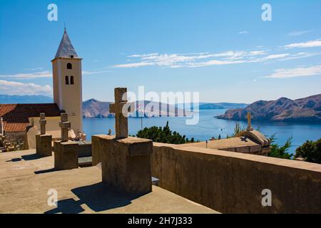 Église Saint-Jean-Baptiste et cimetière, sur une colline surplombant la ville de Baska sur l'île de Krk, comté de Primorje-Gorski Kotar.Aussi appelé Crkva Svetog Ivana. Banque D'Images