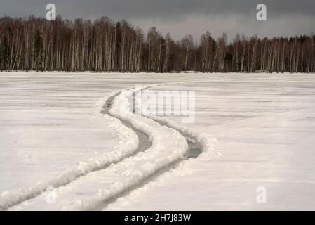 Pistes sinueuses sur un lac gelé.Jour d'hiver.Région de Leningrad. Banque D'Images