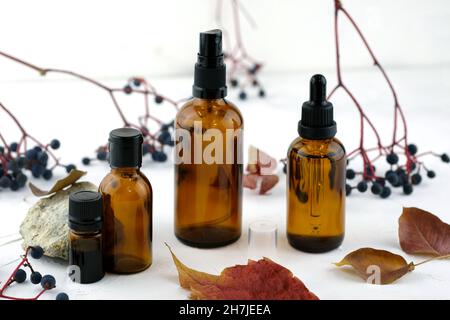 Flacons en verre brun pour cosmétiques contre des articles naturels. Flacons verre closeup de différents volumes.Emballage en verre pour l'huile essentielle.Compte-gouttes, pulvérisation b Banque D'Images