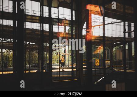 Personne marchant dans une gare routière.Réflexions sur la fenêtre.Station vide d'une ville.Moody style de rue paysage.Photo de haute qualité Banque D'Images