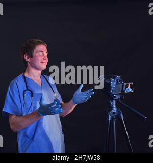 Medic parle de caméra vidéo sur fond sombre, conférence des médecins Banque D'Images