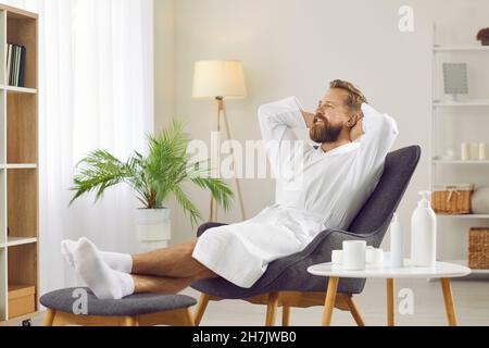 Portrait d'un homme souriant barbu en peignoir qui se détend et profite de son temps libre. Banque D'Images