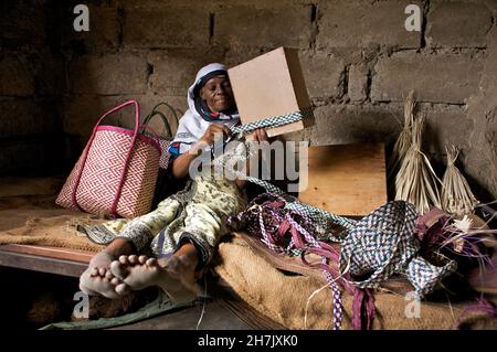 Mzuri Juma, 48 ans, déversait des paniers de pailles dans la région de Jangombe à Zanzibar.En plus des paniers, elle vend du charbon de bois de sa maison pour la compléter Banque D'Images