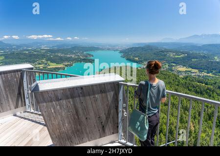 Une femme regarde de la tour d'observation de Pyramenidenkogel jusqu'au lac Wörthersee, Carinthie, Autriche Banque D'Images