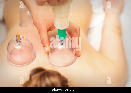 Femme recevant un traitement par immersion sous vide sur le dos couché sur la poitrine dans le salon de massage Banque D'Images