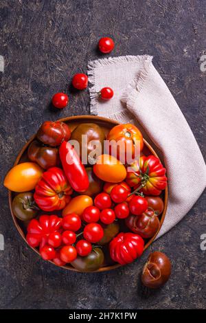 La récolte de tomates assorties.Tomates biologiques colorées sur un grand plat.Tomates différentes variétés.Vue de dessus Banque D'Images