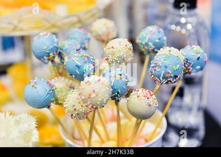 Gros plan de gâteaux blancs et bleus décorés de saupoudrées colorées servis pour l'événement Banque D'Images