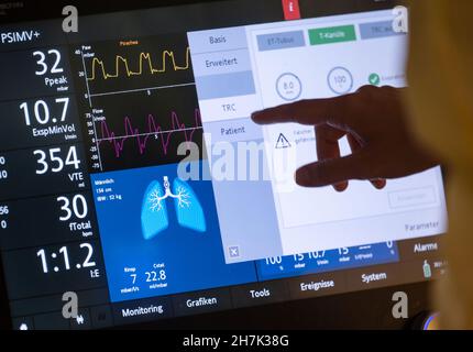 Stuttgart, Allemagne.17 novembre 2021.Le personnel infirmier se tient dans la chambre d'un patient d'une zone séparée pour les patients Covid-19 d'une unité de soins intensifs du Klinikum Stuttgart, devant le ventilateur d'un patient Covid-19 qui est dans un coma artificiel et qui est ventilé.Credit: Marijan Murat/dpa/Alamy Live News Banque D'Images