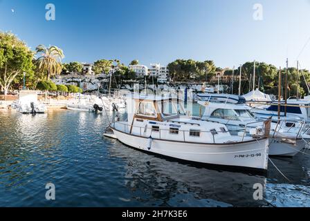 Porto Cristo, Espagne - 12 27 2017: Bateaux au port avec la plage en arrière-plan Banque D'Images