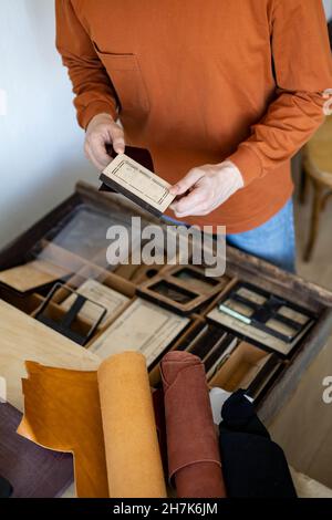 Vue de dessus mains artisanales choix du couteau ou de la perforation pour couper la forme travail avec des choses naturelles Banque D'Images