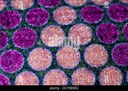 Détail de tapisserie en peluche avec des cercles en forme de triangles abstraits en crème et violet avec un fond vert Banque D'Images