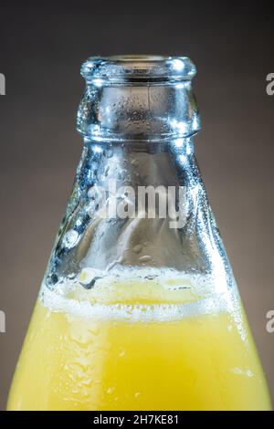 Helsinki / Finlande - gros plan des oranges humides et bouteille de jus d'orange en verre sur la table. Banque D'Images