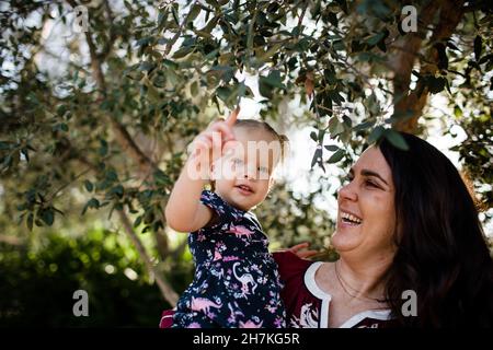 Mère et fille sous l'arbre dans le jardin en Californie Banque D'Images