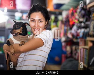 Femme avec zwergpinscher dans la boutique d'animaux Banque D'Images