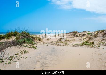 Une vue panoramique des vagues de whitecap rouler sur le plage de sable fin de la préserver island Banque D'Images