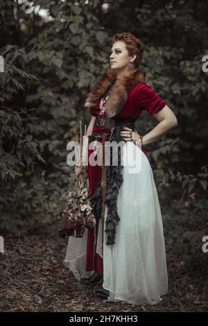 Sorcière avec cheveux courts en robe contre le fond de la nature sauvage Banque D'Images