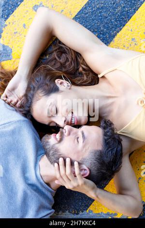 Jeune couple allongé ensemble sur une piste de marche Banque D'Images