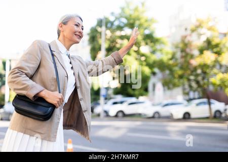 Femme mûre avec sac en toile de transport sur la route Banque D'Images