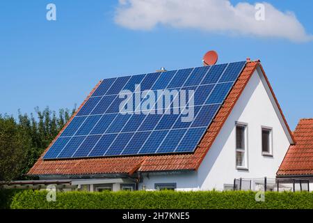 Maison avec toit carrelé recouvert de panneaux solaires Banque D'Images