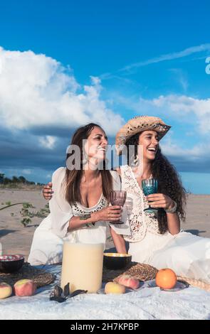 Des amies joyeuses qui se sont contentes de boire un verre le jour du soleil Banque D'Images