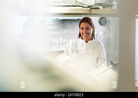 Femme chef souriant dans la cuisine Banque D'Images
