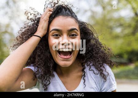 Une femme heureuse avec la tête à la main criant au parc Banque D'Images