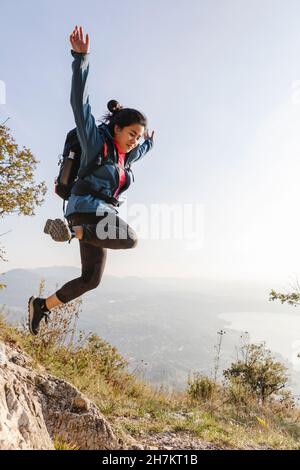 Jeune femme sautant dans les montagnes Banque D'Images