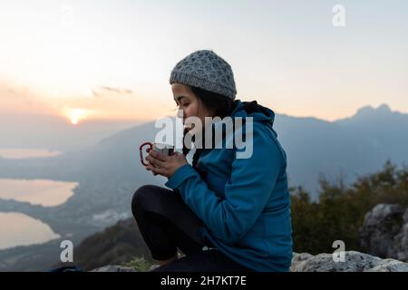 Femme prenant un café en montagne Banque D'Images