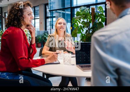 Jeune femme d'affaires en discussion avec des collègues en réunion Banque D'Images