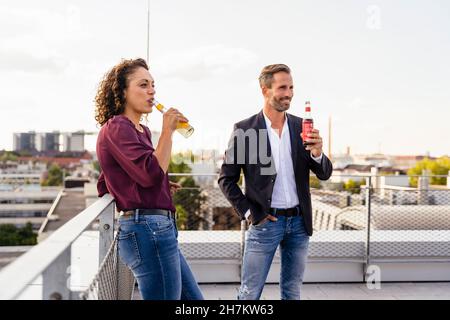 Collègues buvant un verre sur la terrasse du bâtiment Banque D'Images