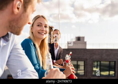 Une jeune femme d'affaires qui se fait boire avec ses collègues sur le toit Banque D'Images