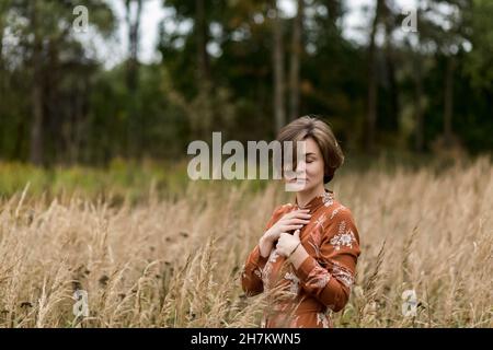 Femme avec les yeux fermés au milieu de la récolte Banque D'Images