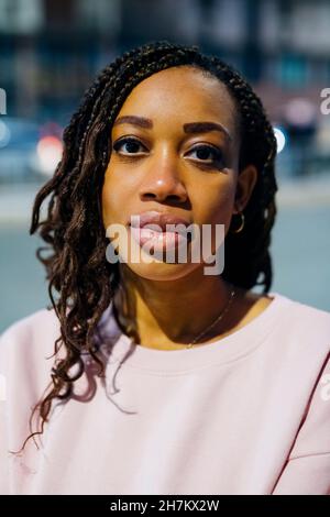 Jeune femme avec des cheveux tressés dans la rue Banque D'Images