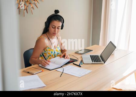 Femme d'affaires écrivant sur le journal à la maison Banque D'Images
