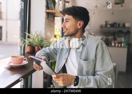 Homme utilisant un Tablet PC pour le paiement sans contact via QR Code dans le café Banque D'Images