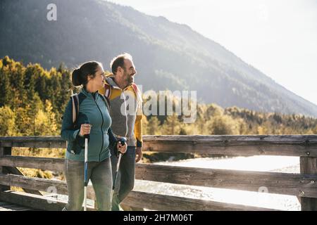 Femme avec un poteau de randonnée pédestre par l'homme sur le pont Banque D'Images