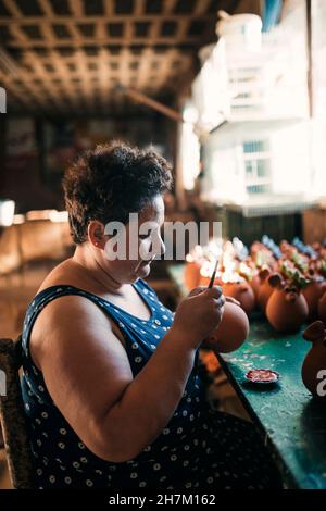 Potier peinture sur la faïence créative à l'établi en poterie Banque D'Images