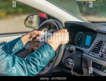 Gros plan d'un conducteur mains sur le volant.Mains de femme tenant le volant.Mise au point sélective, concept photo nouveau pilote, flou Banque D'Images