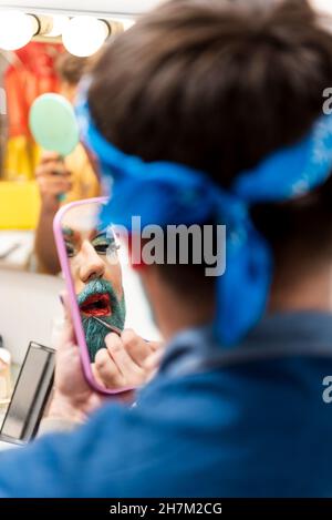 Homme barbu avec miroir de maquillage dans le dressing Banque D'Images