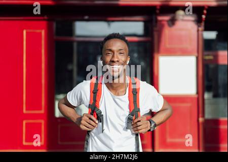 Jeune homme heureux avec sac à dos devant le restaurant Banque D'Images