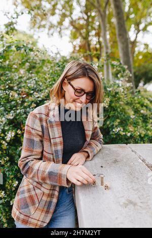 Agent immobilier souriant regardant une petite maison modèle dans un parc public Banque D'Images