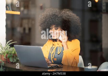 Serveuse attentionnés avec tablette PC donnant sur la fenêtre du café Banque D'Images