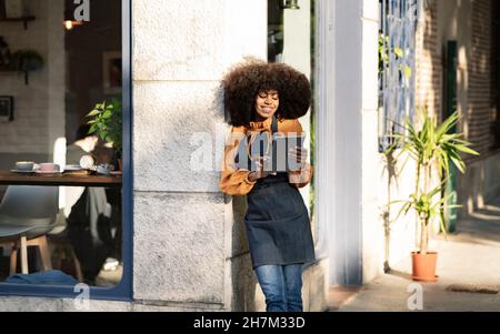 Femme d'affaires attentionnés avec tablette PC à l'entrée du café Banque D'Images