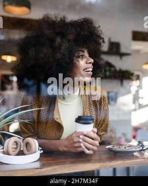 Femme avec code QR payant par téléphone portable au café Banque D'Images